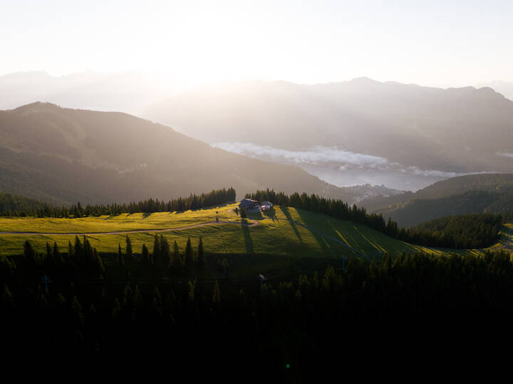 Landscape with hills, forests, and a helicopter on a clearing at sunrise or sunset. | © Marcel Lesch