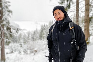 Person snowshoeing in snowy woodland, surrounded by trees in cold weather. | © Katharina Eder Arts 