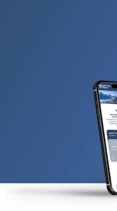 Two smartphones display a winter app with snow sports and skiing information against a blue sky. | © Zell am See-Kaprun