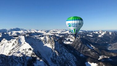 Hot air balloon flying over snow-covered mountains in Zell am See-Kaprun on a clear day. | © Zell am See-Kaprun Tourismus