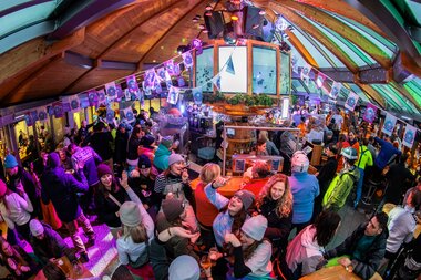 Lively indoor event with many people, colorful lights, and festive decorations during a Dutch Week celebration. | © Tim Mengerink