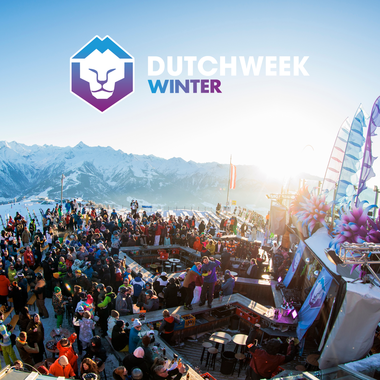Colorful winter event with many visitors, stages, and decorations against a mountain backdrop. | © Dutchweek