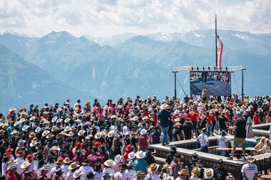 Large crowd attending an outdoor event in the mountains with mountain ranges in the background. | © Zell am See-Kaprun, JOE