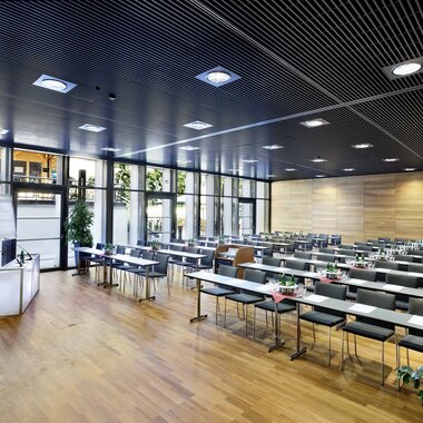Modern seminar room with flexible seating, large windows, and wooden-paneled walls. | © Ferry Porsche Congress Center