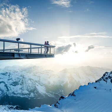 Panoramic view from Kitzsteinhorn with observation deck, snow-covered mountains, and sky in the background. | © Kitzsteinhorn 