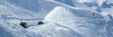 Snowy mountains with snow removal. A rotary plow clears snow from a mountain road. | © Großglockner Hochalpenstraße 