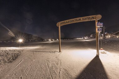 Cross-country skiing on an illuminated trail at night | © Sportalpen