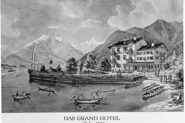 Historical black and white illustration of the Grand Hotel by the lake with mountains in the background, year 1891.