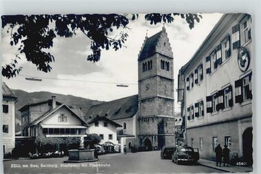 Historical view of the town square in Zell am See with the parish church and old clock tower.