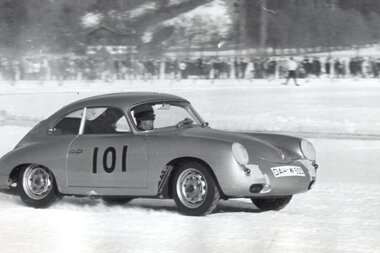 A vintage Porsche sports car with number 101 participating in an ice race, in black and white.
