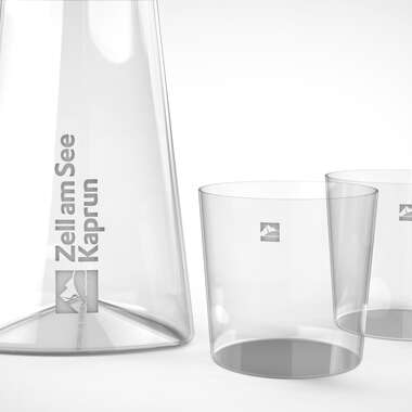 An elegant crystal glass carafe and two matching glasses, transparent and stylish, suitable for drinks. | © Zell am See-Kaprun & Studio F. A. Porsche