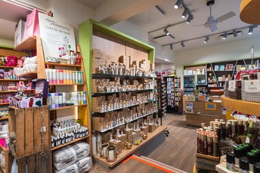 Interior of a well-stocked gift and decor store with shelves full of candles, glass jars, wrapping supplies, and craft materials. | © Johannes Radlwimmer