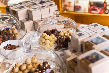 Various chocolates and confections in decorative glass containers on a sweet table. | © Johannes Radlwimmer