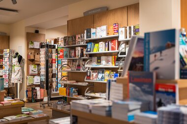 Bookstore with shelves full of books and magazines, in a well-lit retail space. | © Johannes Radlwimmer