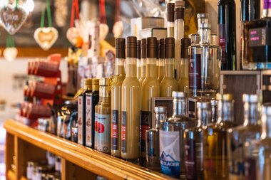 Various bottles of liqueur or spirits on a store shelf. | © Johannes Radlwimmer