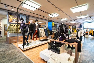 A clothing store featuring winter apparel such as coats, sweaters, and accessories. | © Johannes Radlwimmer