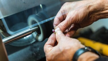 Hands polishing a jewelry piece on a grinding machine. | © Johannes Radlwimmer