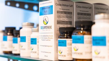 Various dietary supplements and juice bottles on a shelf in a pharmacy. | © Johannes Radlwimmer