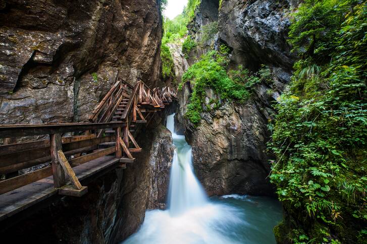 The Sigmund Thun Gorge with wooden walkways and a waterfall in a narrow canyon. | © Zell am See-Kaprun Tourismus