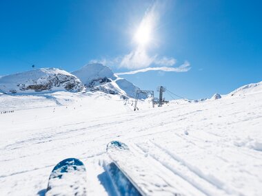 Skiing on snowy slopes with mountain views under a bright sunny sky. | © Zell am See-Kaprun