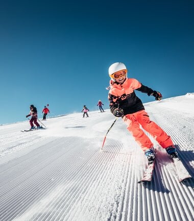 Children skiing on the Schmittenhöhe in Zell am See-Kaprun, sunny winter day with clear blue sky. | © Zell am See-Kaprun Tourismus