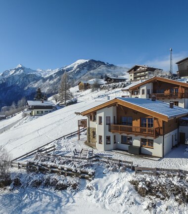 Chalet by the slope with a view of the snow-covered peaks of the Kitzsteinhorn mountains in winter. | © Chalet an der Piste in Kaprun